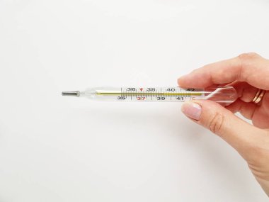 Beyaz arkaplanda elde termometre.