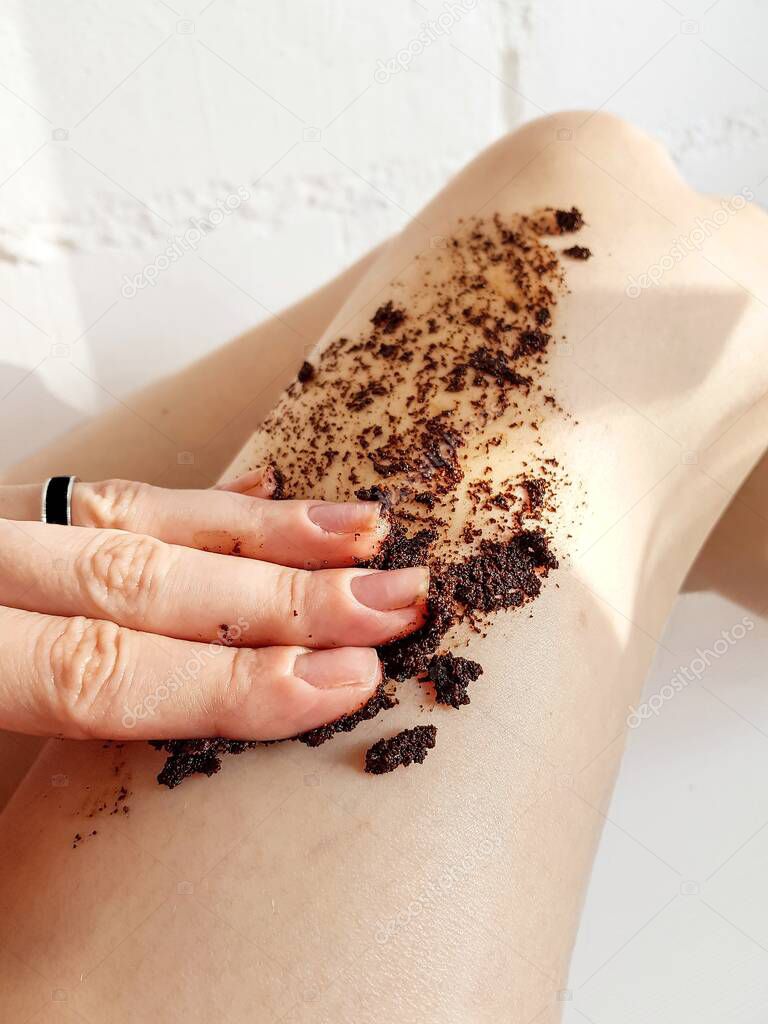 Girls legs close-up with coffee scrub. Spa, beauty treatments, relaxation. Restoring skin elasticity.