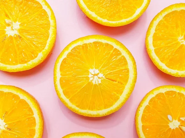 Fatias de laranjas laranja suculentas em um fundo rosa brilhante . — Fotografia de Stock