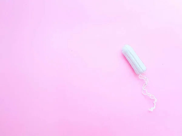 Kvinnors hygien intima tillbehör. En ren vit tampong på en rosa bakgrund. Menstruationscykel Plats för text. — Stockfoto