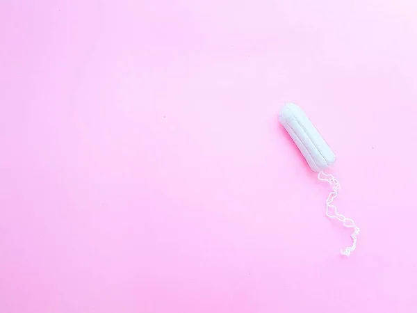 Higiene das mulheres acessórios íntimos. Um tampão branco limpo sobre um fundo rosa. Ciclo menstrual. Espaço para texto . — Fotografia de Stock