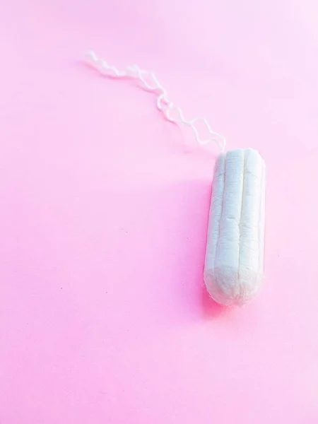 Higiene das mulheres acessórios íntimos. Um tampão branco limpo sobre um fundo rosa. Ciclo menstrual. Espaço para texto . — Fotografia de Stock