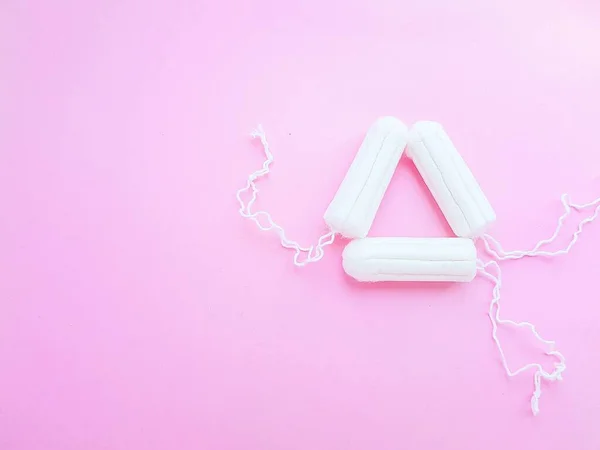 Higiene das mulheres acessórios íntimos. Um tampão branco limpo sobre um fundo rosa. Ciclo menstrual. Espaço para texto . — Fotografia de Stock