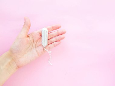 Kadınların hijyen aksesuarları. Pembe arka planda temiz beyaz bir tampon. Adet döngüsü. Metin için boşluk.