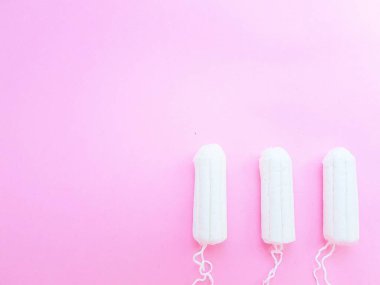 Kadınların hijyen aksesuarları. Pembe arka planda temiz beyaz bir tampon. Adet döngüsü. Metin için boşluk.