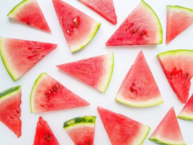 Parlak sulu kırmızı karpuz beyaz arka planda dilimler halinde kesilmiş. Metin için boşluk.
