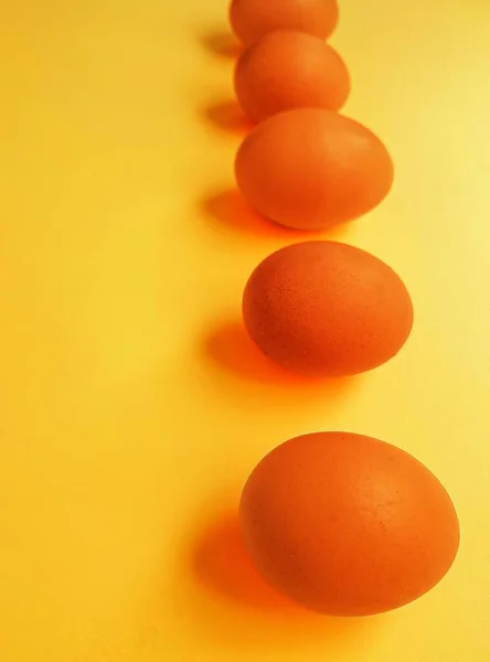 Chicken yellow eggs on a bright yellow background. Space for text.