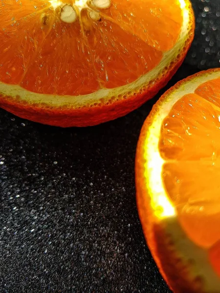 Orange bright juicy on a black shiny background. Place for the buyers text. Close up. — Stock Photo, Image