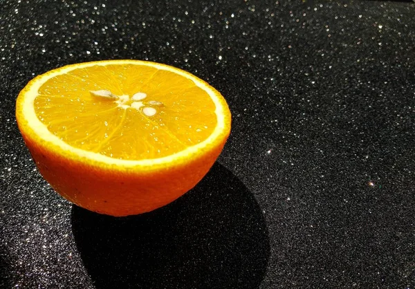 Laranja suculento brilhante em um fundo brilhante preto. Lugar para os compradores texto. Fechar . — Fotografia de Stock