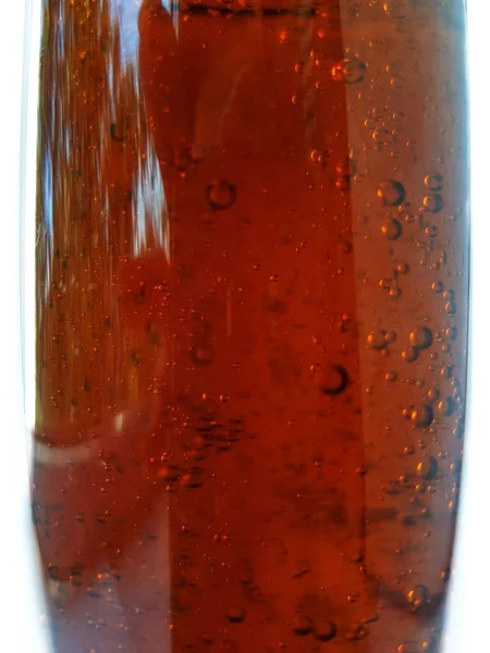 Air bubbles in a brown liquid bottle on a white background with space for brand text. — Stock Photo, Image