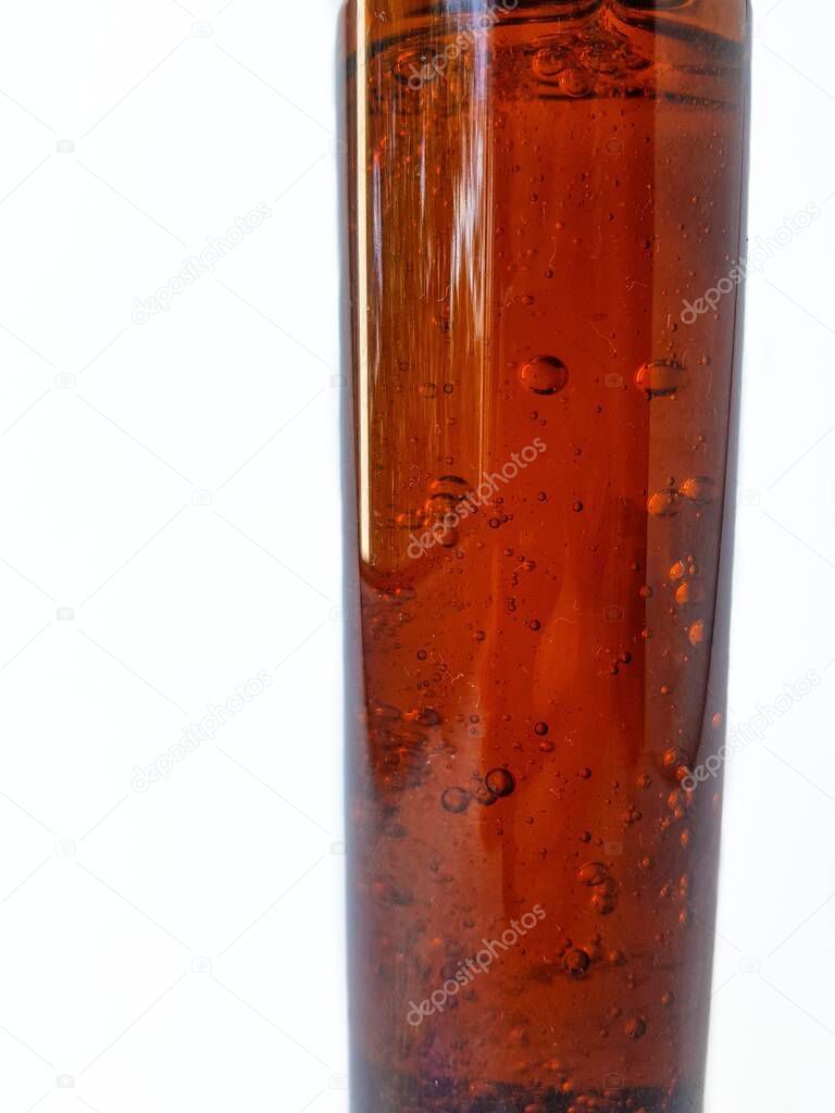 Air bubbles in a brown liquid bottle on a white background with space for brand text.