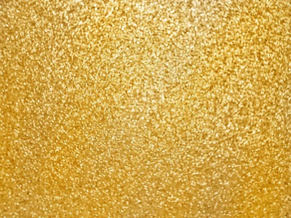 Defocusing. Golden textured shiny background with glitter. Holidays and birthdays. Space for text.