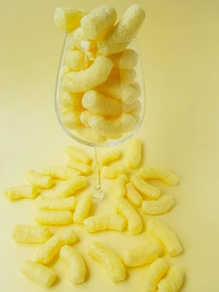 Кукурузные палочки в высоком прозрачном стекле на желтом фоне . — стоковое фото