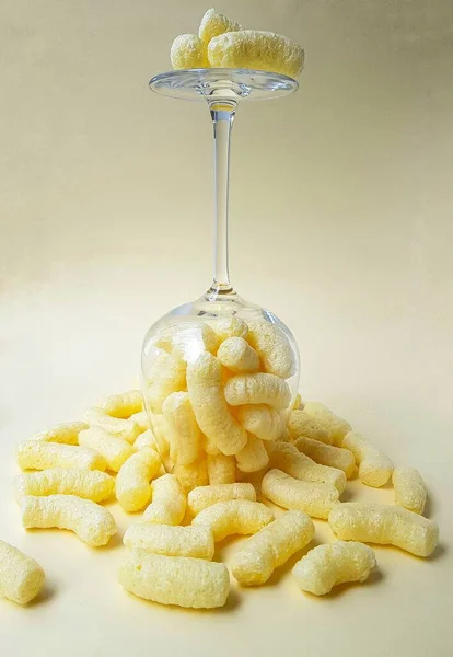 Kukoricadarak magas átlátszó üvegben sárga alapon. — Stock Fotó