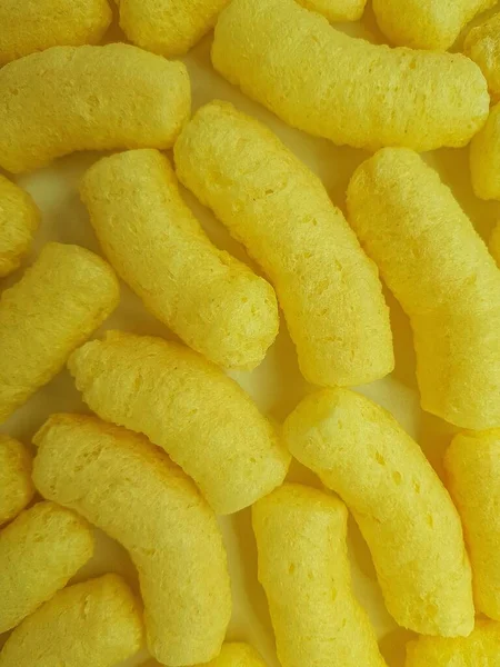 Żółte paluszki kukurydziane na żółtym tle. — Zdjęcie stockowe