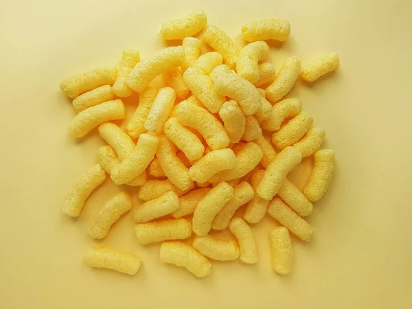 Żółte paluszki kukurydziane na żółtym tle. — Zdjęcie stockowe