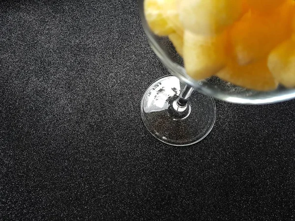 Bâtonnets de maïs jaune dans un verre transparent sur fond noir. — Photo