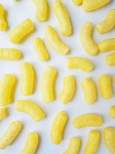 Κίτρινο καλαμπόκι κολλάει σε ένα λευκό πιάτο σε λευκό φόντο. — Φωτογραφία Αρχείου