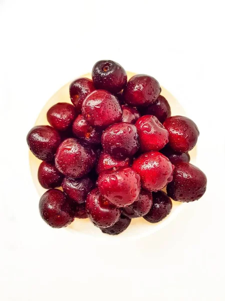 Bright juicy red cherry on a white background in drops of water. — Stock Photo, Image