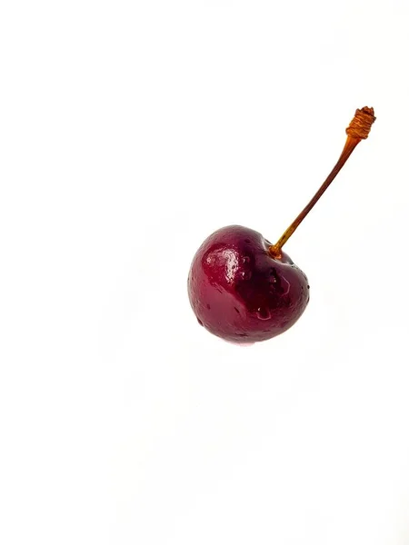 Black ripe juicy cherry on a white background with drops of water. A place for text. — Stock Photo, Image