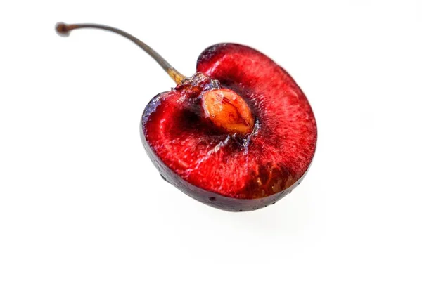 Juicy ripe red cherry cut in half with a bone on a white background. A place for text. — Stock Photo, Image