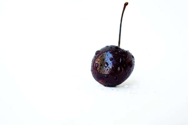 Šťavnaté vyprané zralé černé třešně na bílém pozadí s kapkami vody. — Stock fotografie