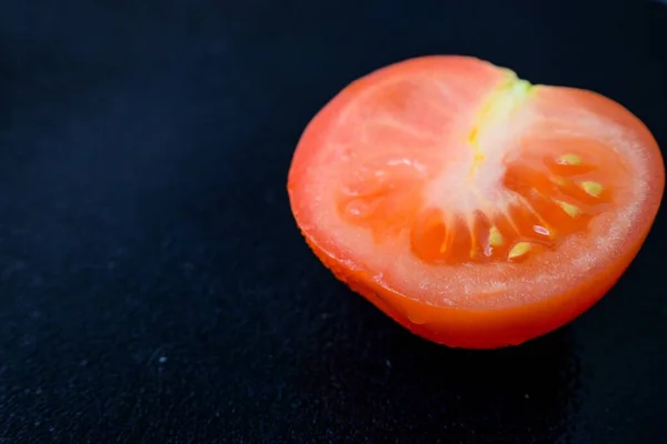 色泽鲜亮多汁的红色西红柿，底色黑色，叶干分明. — 图库照片