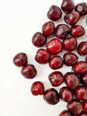 Beyaz arka planda parlak, sulu bir kiraz. Metin için bir yer.