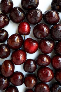 Beyaz arka planda parlak, sulu bir kiraz. Metin için bir yer.