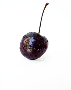 Beyaz arka planda bir damla suyla sulu, olgun kiraz..