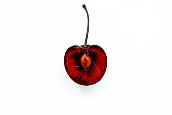 Bright ripe juicy cherry cut in half with a bone inside on a white background. — Stock Photo, Image