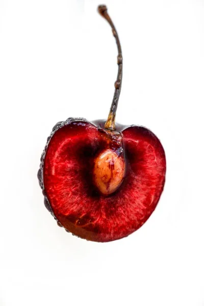 Bright ripe juicy cherry cut in half with a bone inside on a white background. — Stock Photo, Image