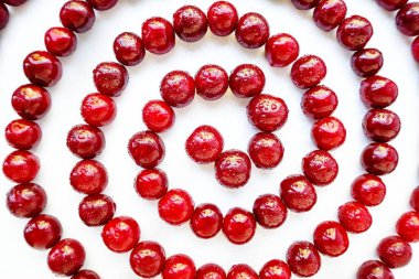 Beyaz arka planda kırmızı sulu olgun kiraz.