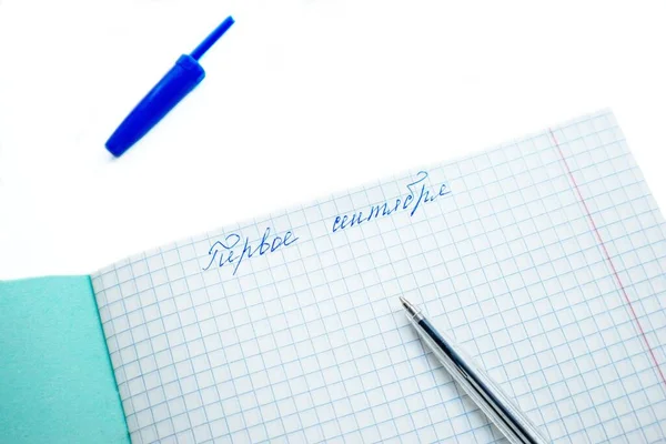 Am 1. September der Text in russischer Sprache auf einem weißen Blatt Notizbuch in einem Käfig auf weißem Hintergrund mit blauem Kugelschreiber. — Stockfoto