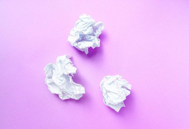 Mor arka planda bir kafeste buruşmuş beyaz bir kağıt parçası..