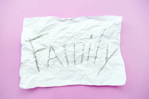 Текст сім'ї на білому аркуші паперу в клітці на фіолетовому тлі. Руйнування і розлучення. Крок за кроком. Сімейна безпека . — стокове фото