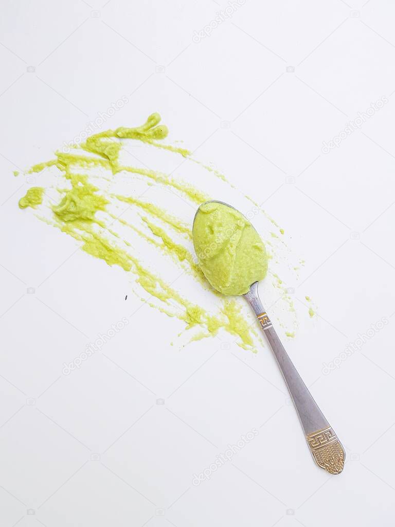 Spoon the wasabi on a stained surface on a white background.
