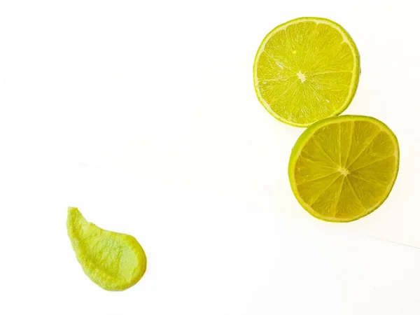 Green juicy sour lime and a drop of wasabi on a white background. — Stock Photo, Image