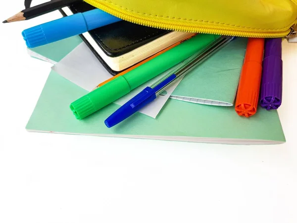 Szkolny żółty plecak z notatnikami i materiałami szkolnymi na białym tle. Wracamy do szkoły.. — Zdjęcie stockowe