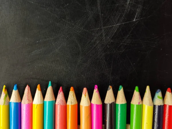 Buntstifte auf einer schwarzen Tafel. Zurück zur Schule. — Stockfoto