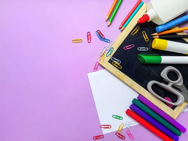 Kalkbräda, färgade pennor på lila bakgrund. Tillbaka till skolan. — Stockfoto