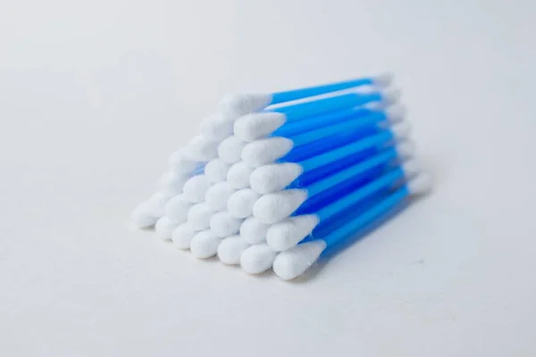 Oorstokjes met blauw plastic op een witte achtergrond. Persoonlijke hygiëne en zelfverzorging. Cosmetologie en geneeskunde. — Stockfoto