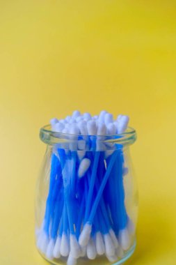 Kulak pamuğu sarı arka planda mavi renktedir. Kozmetik ve tıp. Kişisel hijyen ve bakım.