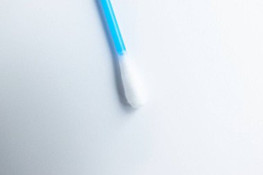 Pamuk, beyaz arka plana mavi kulak plastiği yapıştırır. Kişisel hijyen ve bakım. Kozmetoloji ve tıp.