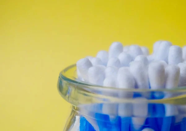 Cotton sticks ear blue plastic on a yellow background. Personal hygiene and care. Cosmetology and medicine. — Stock Photo, Image