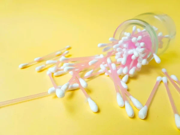 Cotton sticks pink plastic on a yellow background. Personal hygiene and health. Cosmetology and medicine. — Stock Photo, Image