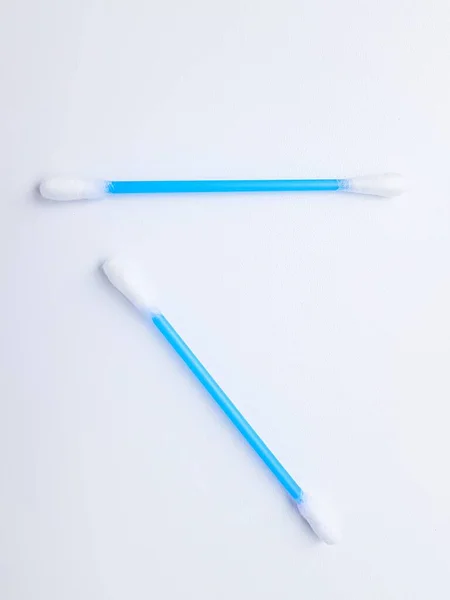 Palos de algodón de plástico azul sobre un fondo blanco. Higiene y cuidado personal. Cosmetología y medicina. — Foto de Stock