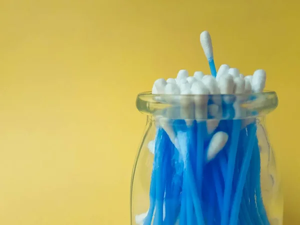 Algodão varas orelha azul plástico em um fundo amarelo. Higiene pessoal e cuidados. Cosmetologia e medicina . — Fotografia de Stock