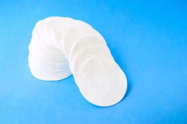 Mavi arka planda pamuk pamuk diskler. Kozmetik ve tıp. Kendine dikkat et..