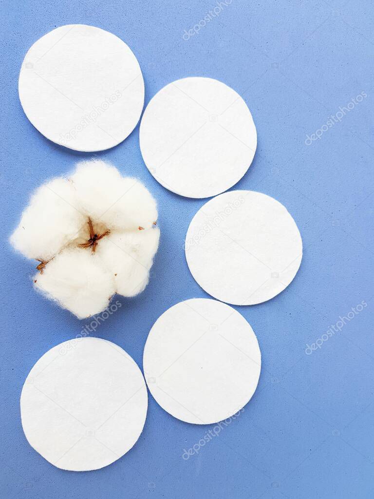 Cotton discs on a blue background. Cosmetology and medicine. Taking care of yourself.